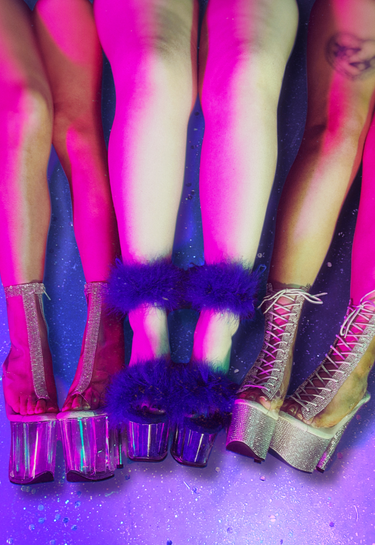 Close-up of colorful high-heeled shoes with fluffy accents on a purple background